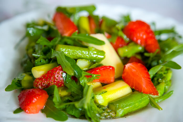 Recette d'asperges en salade avec des fraises et de la roquette