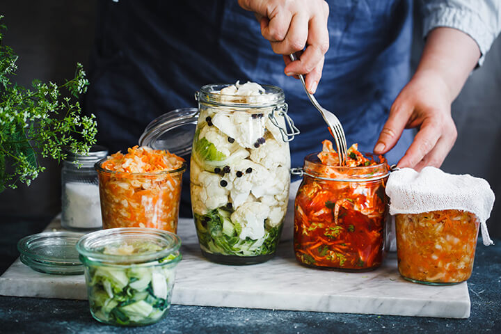 Aliments fermentés : pots de différents légumes fermentés sur une table