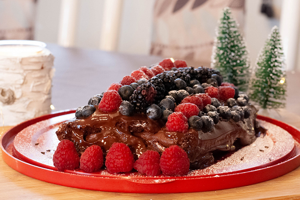 Bûche de Noël végétalienne au chocolat avec des framboises, bleuets et mûres