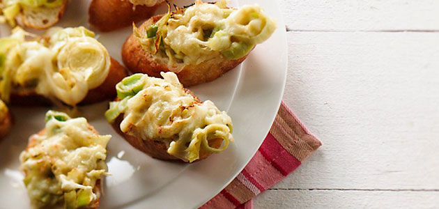 Canapés au beurre de poireaux avec moutarde et fromage sur un pain baguette