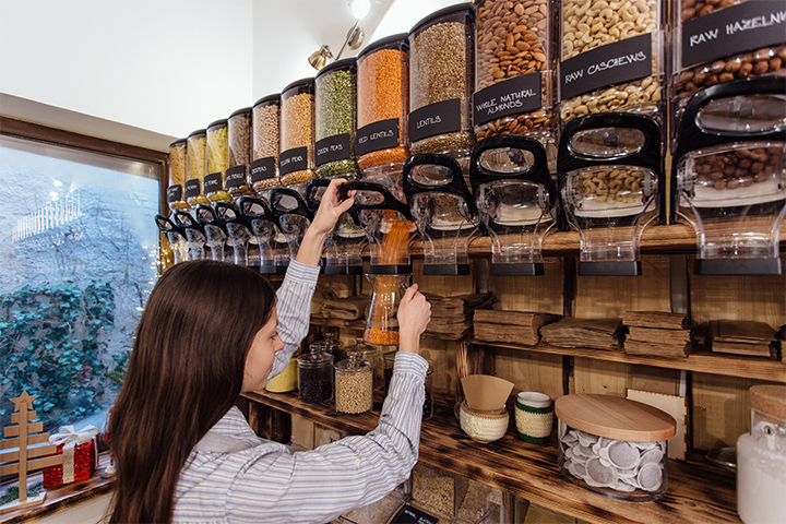 Une dame achète des produits en vrac avec ses contenants réutilisables dans une épicerie zéro déchet