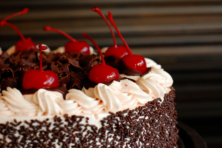 Gateau forêt-noire sans lait orné de cerises et d'une gourmande garniture au chocolat