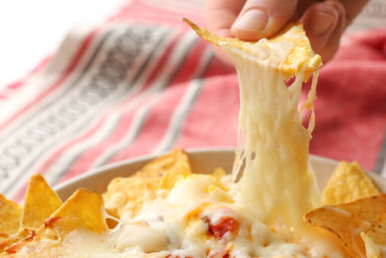 Nachos maison aux trois fromages avec légumes et du fromage qui s'étire