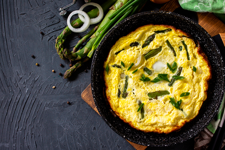 Une omelette rustique dans une poêle en fonte.