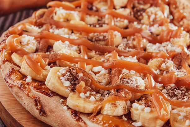 Pizza dessert sucrée aux bananes avec un coulis de caramel sur pâte feuilletée