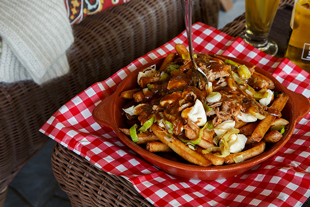 Poutine avec poireaux, porc effiloché, sauce demi-glace, cassonade, ketchup et moutarde de Dijon