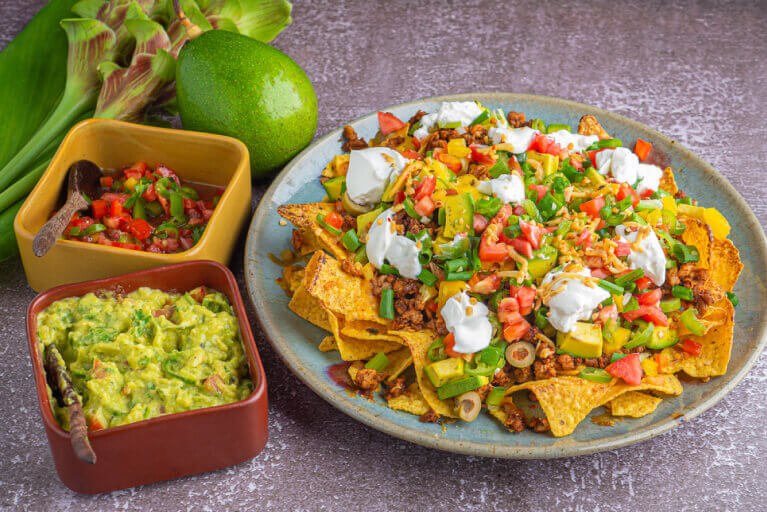 Recette de nachos maison suprêmes garnis de viande, légumes et condiments