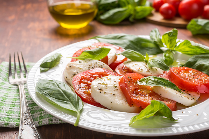 Salade caprese italienne avec fromage mozzarella, tomates, basilic, sel, poivre et huile d’olive