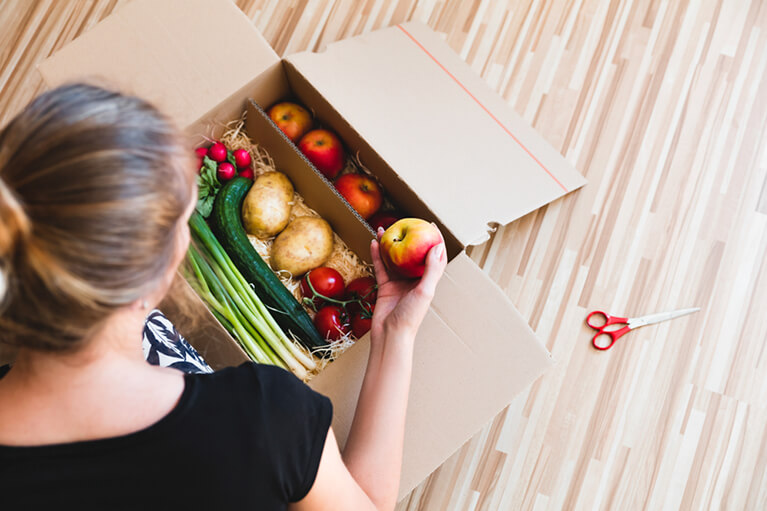 Une femme se fait livrer des fruits et légumes frais de la région à domicile