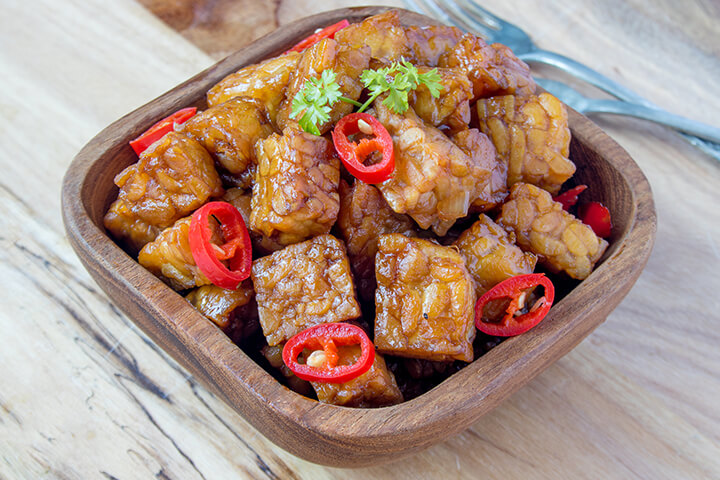 Tempeh glacé à l'orange dans servi dans un bol en bois