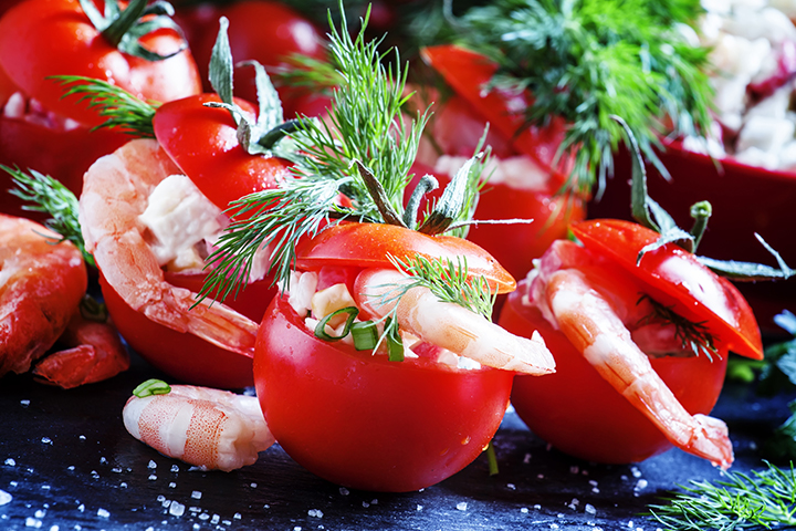 Tomates farcies avec du fromage, des herbes et des crevettes