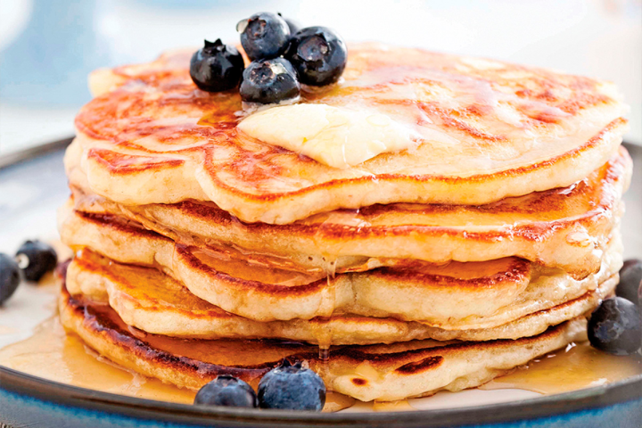 Pancakes aux bananes avec des bleuets et du sirop d’érable en garniture pour une recette de brunch traditionnel