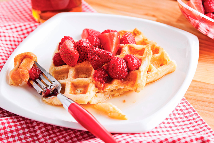 Gaufres classiques garnies de fraises, de framboises et de sirop d’érable pour une recette de brunch traditionnel