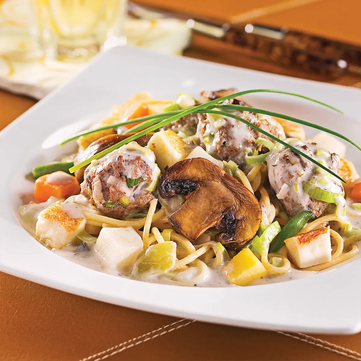 Veal meatballs over dried tomatoes pasta, and mushrooms with leeks sauce