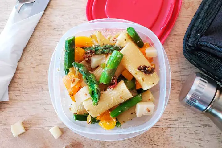 Pâtes aux asperges avec du poivron orange, du fromage à la crème et des cubes de fromage Oka