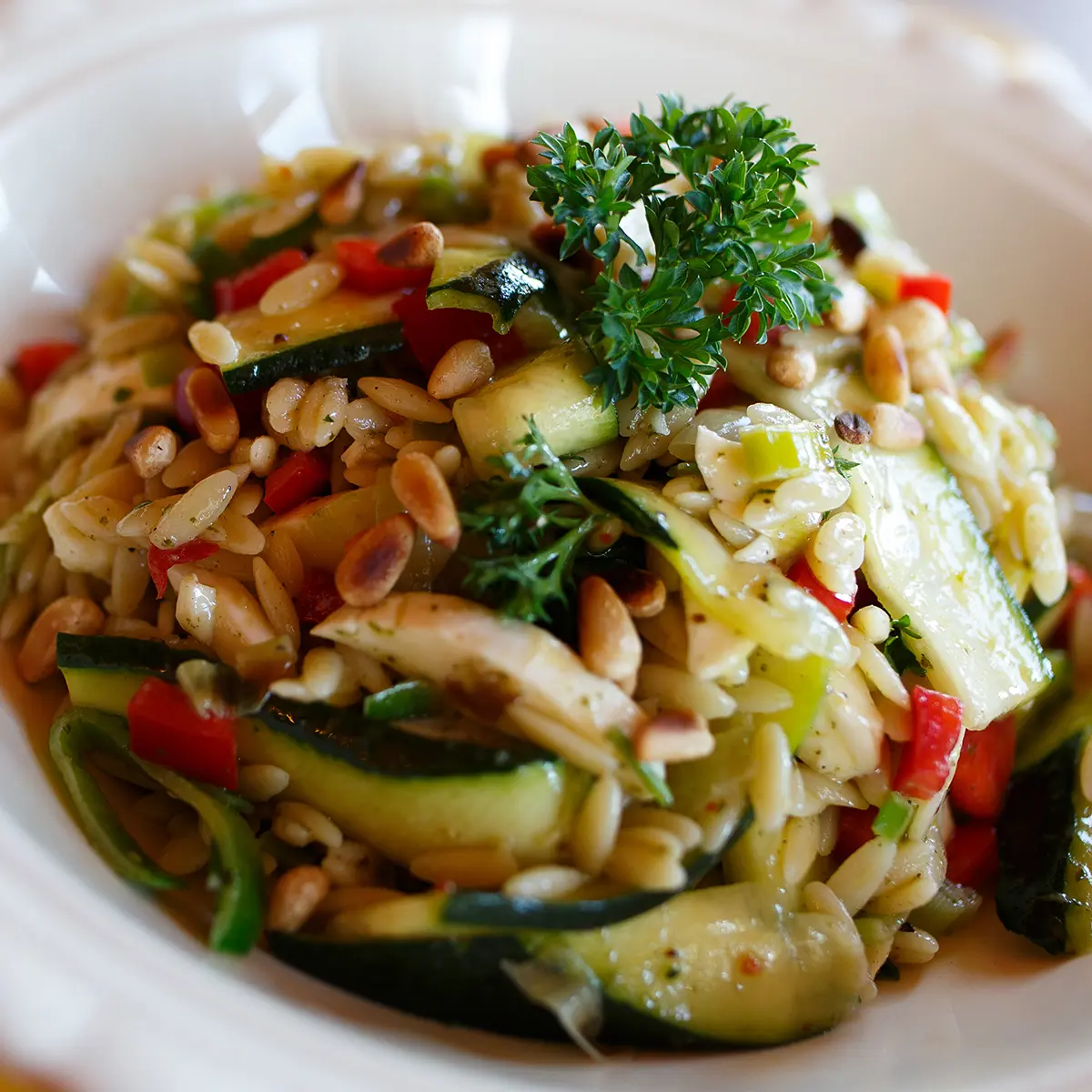 Orzo salad with zucchinis, cherry tomatoes, bocconcini and leeks